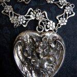 Bat Woman heart-shaped photo locket made by Unger Brothers, paired with a handmade antique silver French Art Nouveau sautoir chain with floral  filigree design, circa 1900.