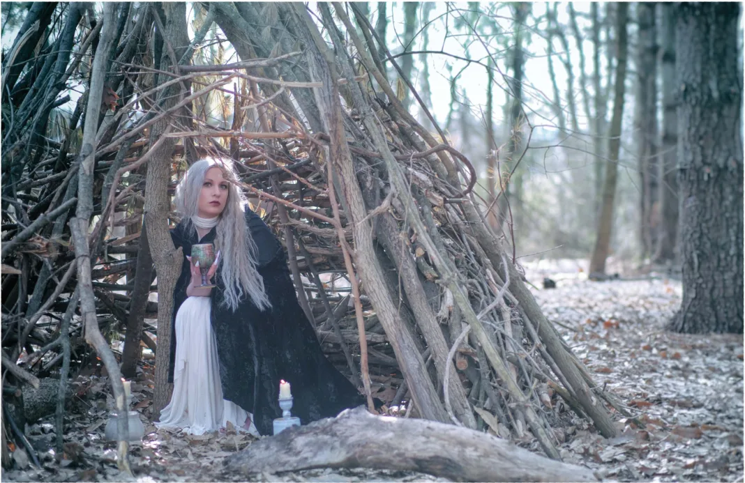 Winter Enchantment: Ceramicist Rachael Platt holding a lit manifesting jar under the full moon, surrounded by illuminated jars in a forest setting. Photography by steve parke