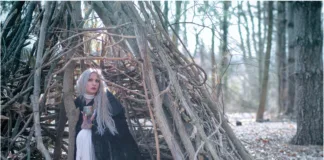 Winter Enchantment: Ceramicist Rachael Platt holding a lit manifesting jar under the full moon, surrounded by illuminated jars in a forest setting. Photography by steve parke