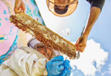 Mark Berman of Anna Bee’s Honey holding a frame of bees for a child to inspect