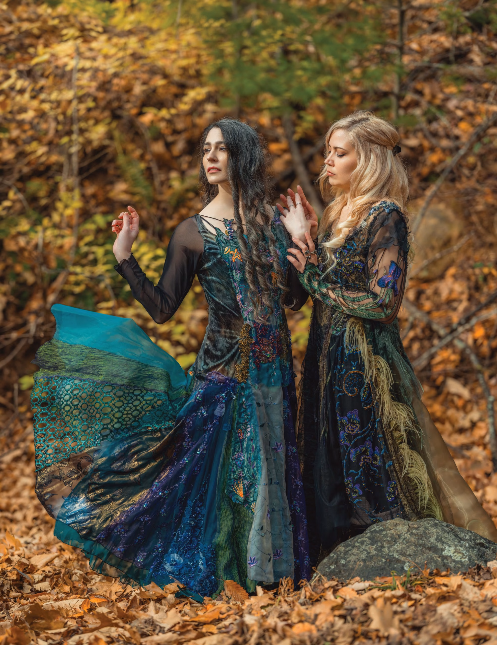 Two magical sisters in enchanted witch costumes in a forest Two magical sisters in enchanted witch costumes in a forest